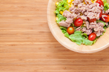 Tuna salad in bowl on wooden table.