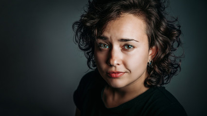 close-up portrait of smiling young woman with curly hair with copy space, casual style