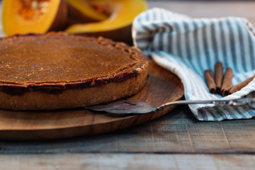 pumpkin pie  with cinnamon and fresh pumpkin on rustic wooden background
