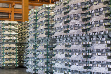 Aluminum ingot bar stacked in warehouse. Raw material for industrial concept. General cargo warehouse concept