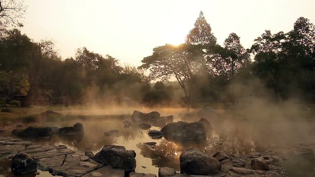 volcanic natural hot spring mineral water pool with steam spa and sun reflect light , travel landmark background ,lampang thailand landscape ,colorful dark tone