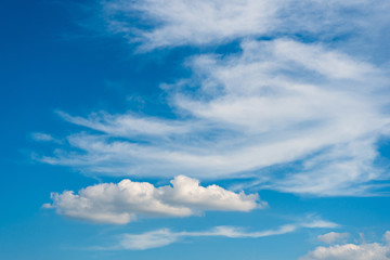Sunny weather with cumulus and cirrus clouds on blue sky