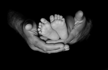 Newborn feet in fathers hands