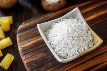 Ceramic bowl with the rice on wooden board.