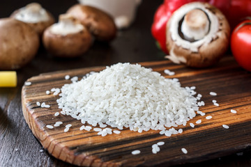 Bunch of rice on a wooden kitchen board.