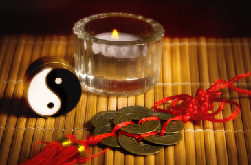 Yin yang, oriental chinese lucky coins, a candle like a concept for china astrology and chinese esoteric topics and oriental belief 