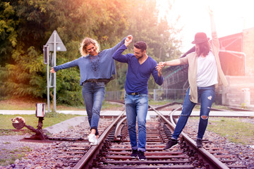 three friends walking on train tracks