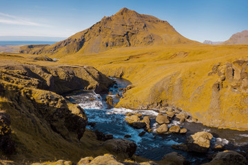 Fototapeta na wymiar Iceland, mountain river, rock in the background