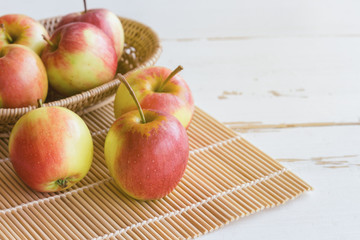 Fresh red fuji apple and in basket put on wood table for background or wallpaper in vintage tone style. Delicious sweet and juicy fuji for goodness cooking or bakery.Fuji apple has origins in Japan.