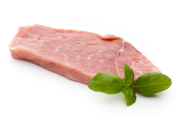 Fresh pork fillet with basil on a white background.