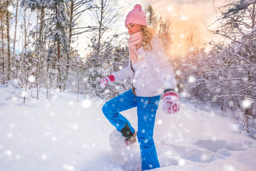 Winter sport activity. Woman with snowshoes on fluffy snow in forest. Beautiful landscape with...
