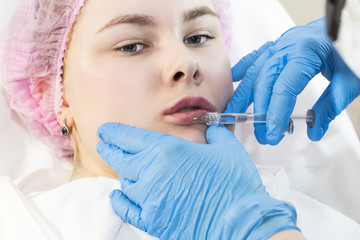The girl undergoes the procedure of cosmetic surgery to increase the lips 