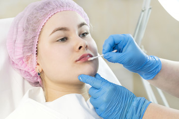 The girl undergoes the procedure of cosmetic surgery to increase the lips 