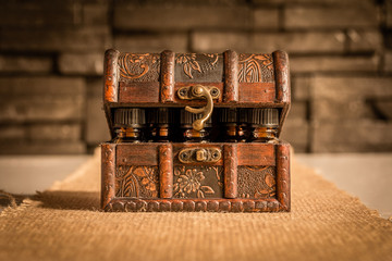 Bottles of tincture or potion in a retro styled.old treasure chest on fabric background