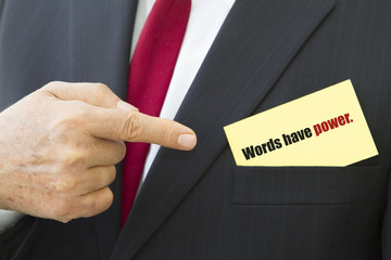Businessman showing a card with text WORDS HAVE POWER.