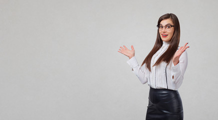 Business woman gesturing with hands on a gray background. Place for text for advertising.