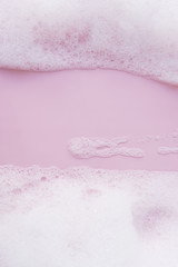 white foam bubbles on pink background