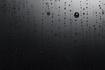 Water drops on a black surface, abstract background.