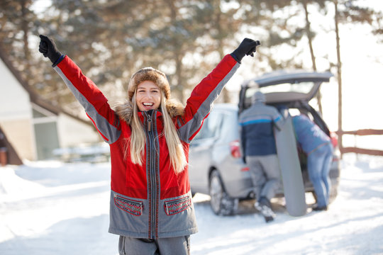 Happy woman with hands up enjoying in winter