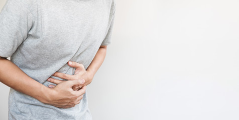 a man touching his stomach, stomach pain and others stomach disease concept, on white background with copy space