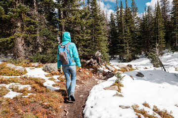 Tourist with backpack hiking on snowy trail