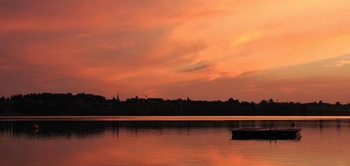Bright orange sky over lake Pfaeffikon. Summer sunset in Switzerland.