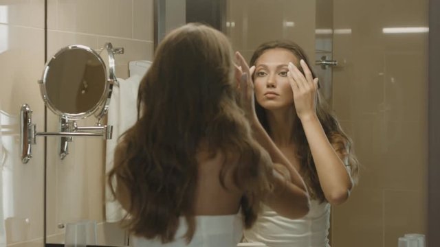 Beautiful girl looks in the mirror before going out