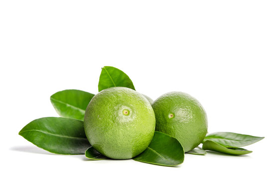 two green limes with leaves isolated on white background
