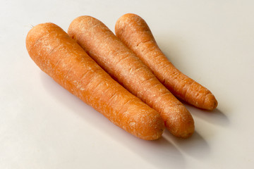 Three carrots on a background of a white color