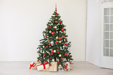 Christmas tree with red gifts in the white room Christmas