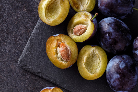 juicy plums slice on dark background.