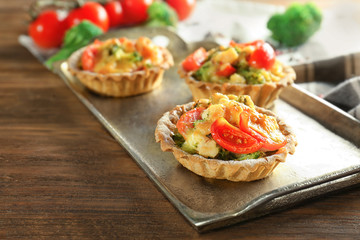 Delicious crispy tarts with broccoli on metal tray