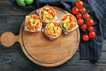Delicious crispy tarts with broccoli on wooden board