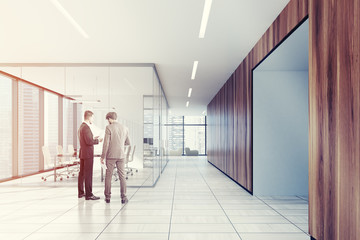 White and wooden meeting room, armchairs, men