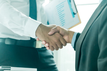 Businessmen shake hands and finish meeting in daylight.