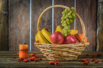 wicker basket with fruits  on wooden background 