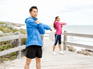 Fototapeta premium Young couple at the seaside doing exercises