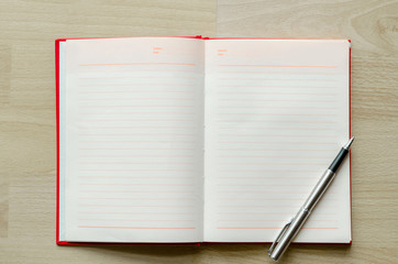 blank notebook with pen on wood table Text input area