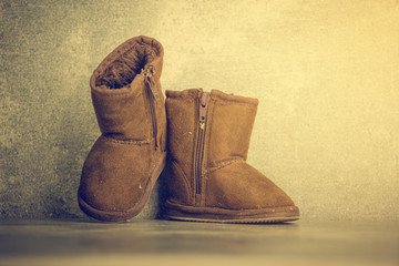 Brown kid boots on concrete background