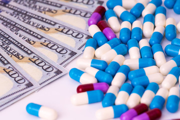 Medicine capsules with dollar banknote. Business, finance concept