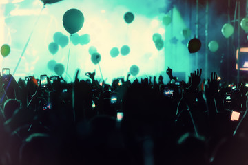 Hand with a smartphone records live music festival