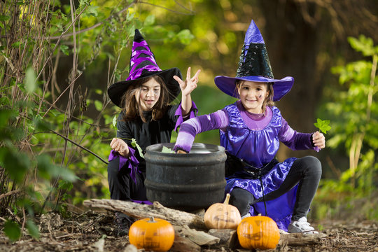 Girls in a costume of witches making magic potion