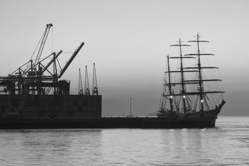 Tagus river, cranes and ship in a foggy dawn