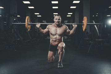 Fototapeta na wymiar Handsome model young man training legs in gym