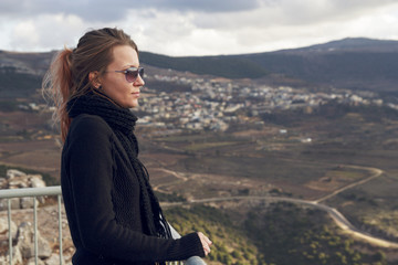 A young woman looks sadly at the mountain range. Israel