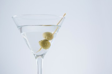 Cocktail martini with olives on table