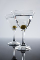 Cocktail martini with olives on table