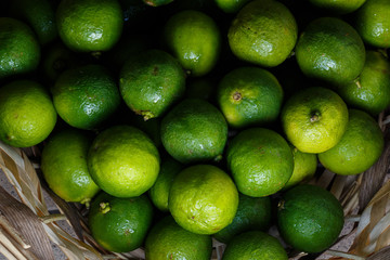 Closeup of many green juicy lime fruits in basket