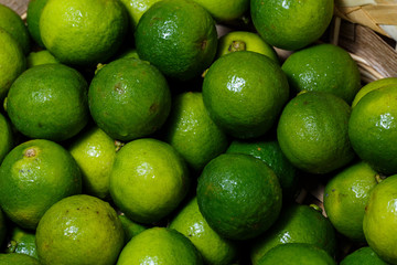 Closeup of many green juicy lime fruits in basket