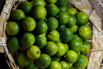 Closeup of many green juicy lime fruits in basket